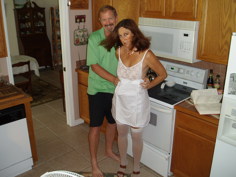 Candi Annie and Al posing together in their kitchen for an amateur swinger couple photo
