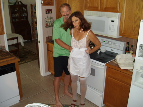 Candi Annie and Al posing together in their kitchen for an amateur swinger couple photo