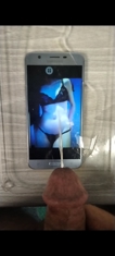 Cum tribute aimed at a lingerie photo displayed on a smartphone