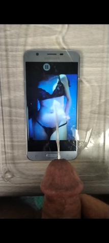 Cum tribute aimed at a lingerie photo displayed on a smartphone