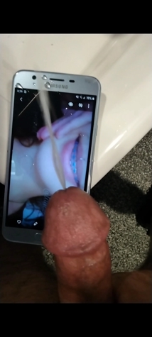 Explicit cum tribute featuring an erect penis ejaculating onto a phone displaying adult content