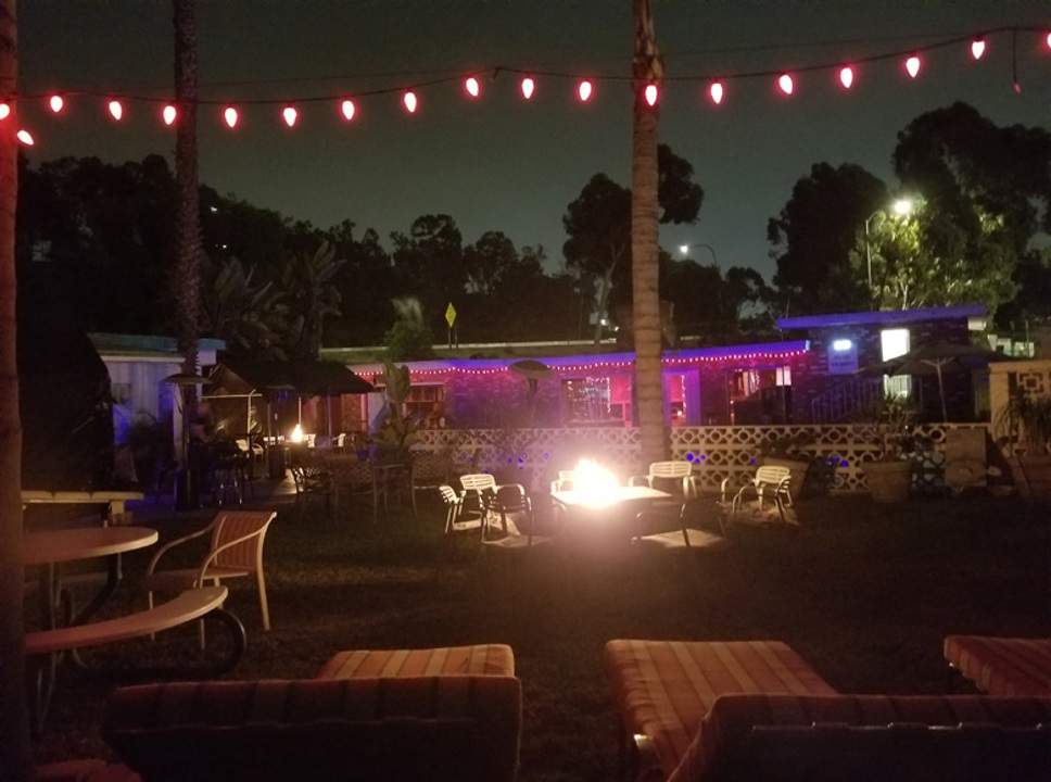 Outdoor lounge with fire pit and string lights