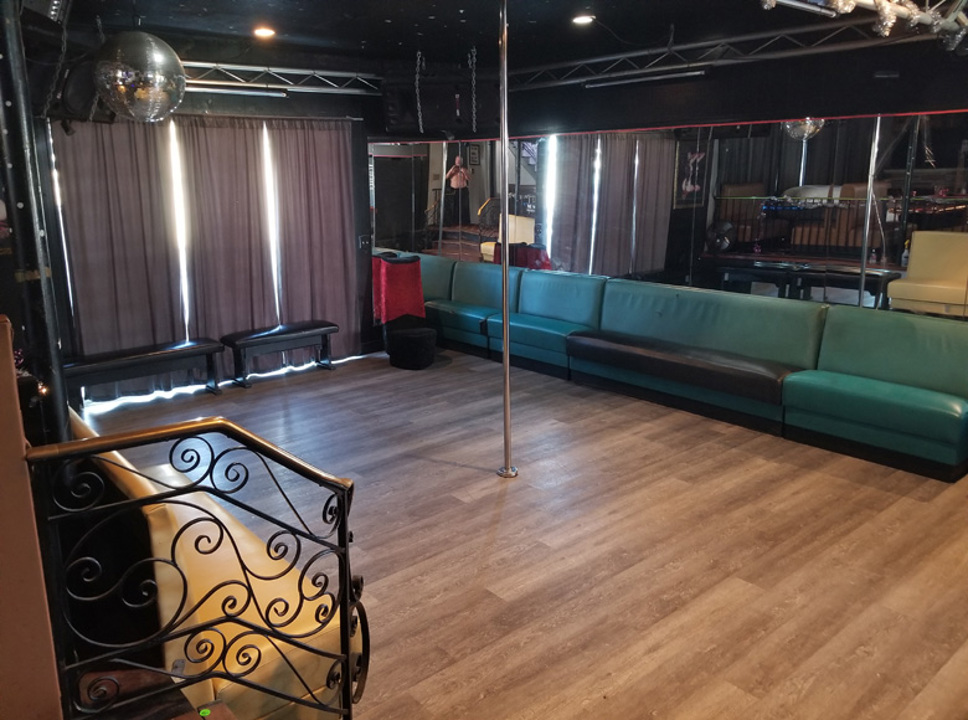 Mirrored dance floor with pole and lounge seating