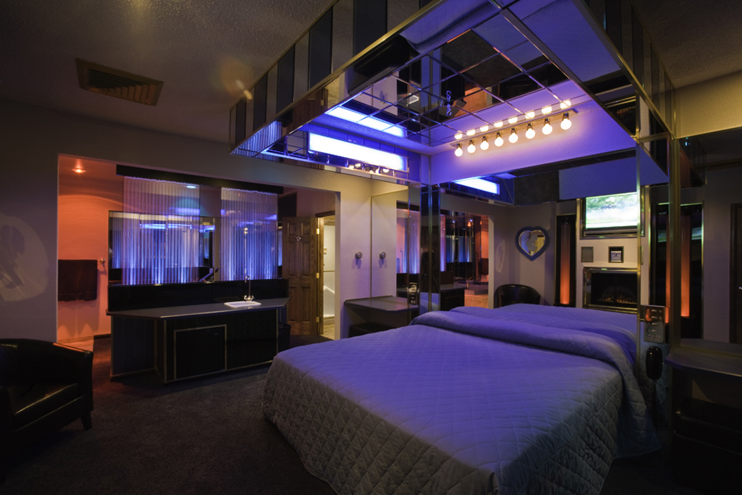 Suite bedroom with mirrored ceiling and blue and red mood lighting
