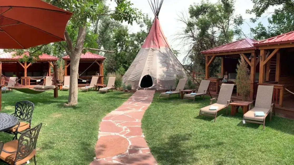 Tipi surrounded by outdoor cabanas and lounge chairs