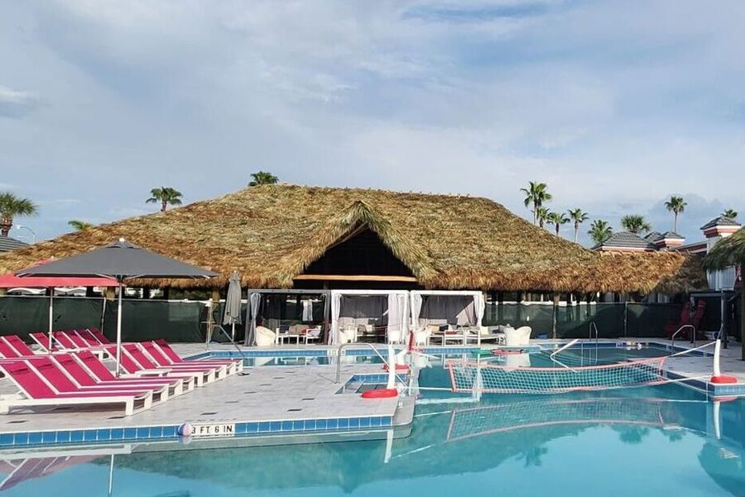 Pool with tiki hut and lounge chairs