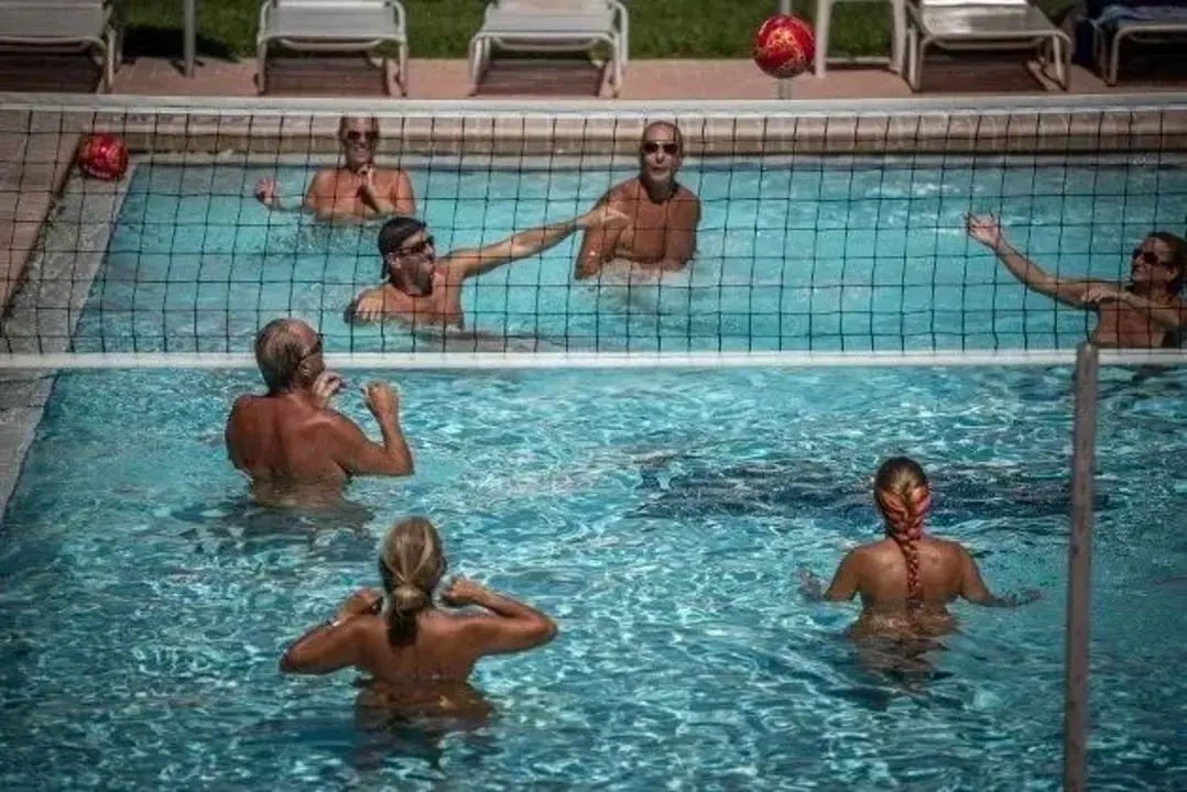 Guests playing water volleyball in a pool