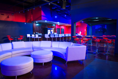 White curved couches overlooking the bar at Colette Houston, Texas