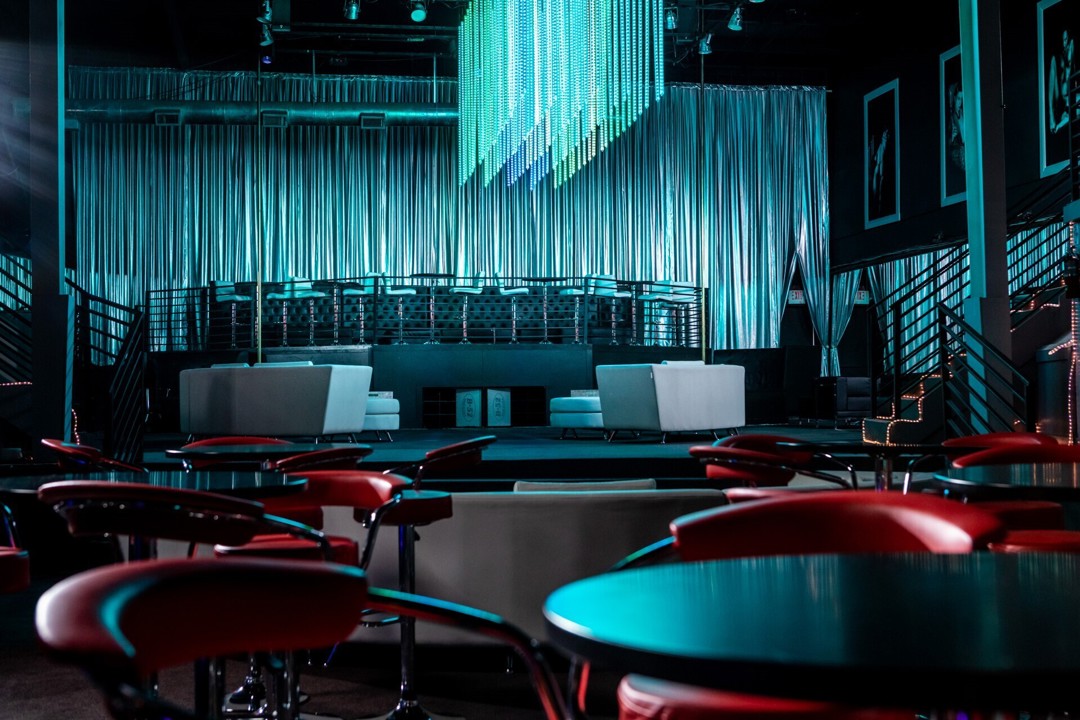 Main club interior with round tables and red chairs