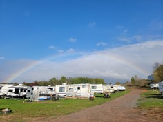 Freedom Valley Campground RV sites under a rainbow in Cushing, Wisconsin