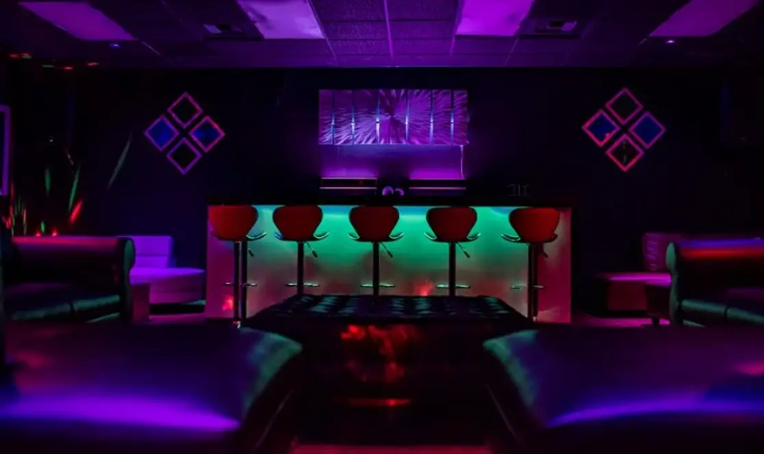 Main bar interior with colorful neon lighting and bar stools
