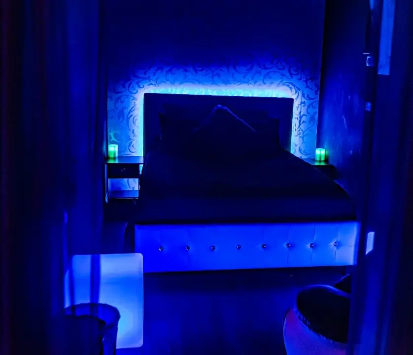 Private bedroom with illuminated headboard and blue lighting