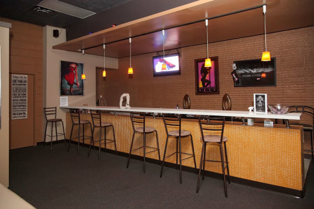 bar with stools and wall-mounted TVs