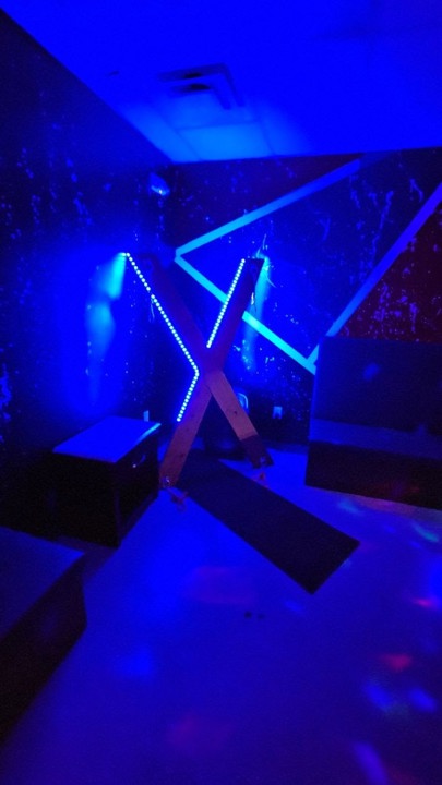 Blue-lit BDSM cross in a playroom