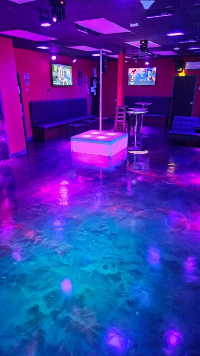 Illuminated pole dance area with lounge seating