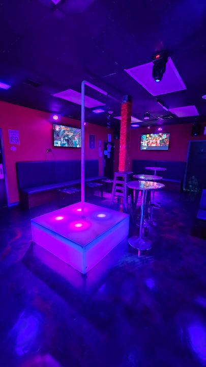 Illuminated dance pole and lounge seating