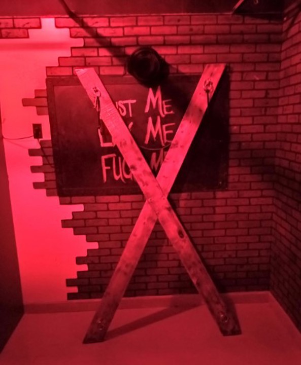 Club Red Door dungeon area with wooden St Andrew's cross
