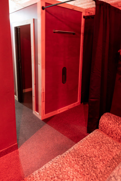 Red-themed room with curtained alcove and specialty fixture