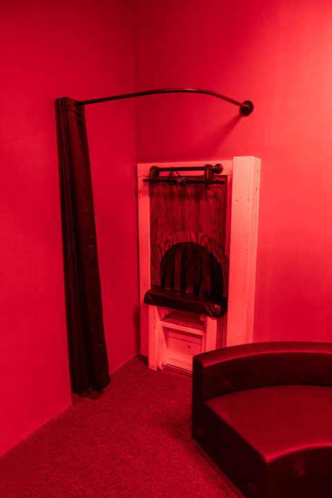 Red-lit private room with specialty play furniture