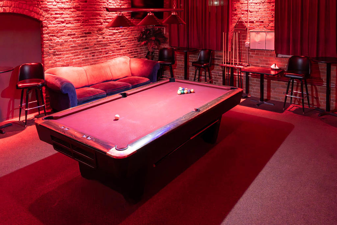 Pool table lounge with sofa and cue racks